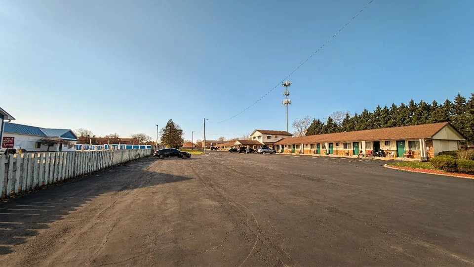 Single-story motel buildings and a wide paved parking area