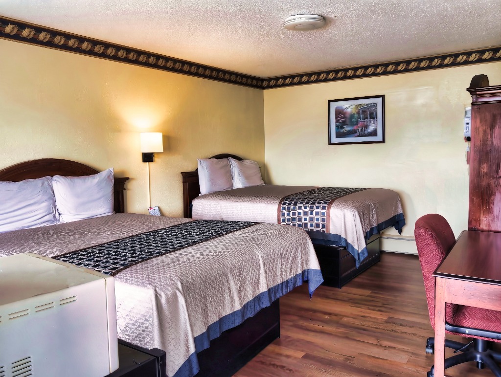 Delta Motel double queen room with two queen beds, desk, and microwave