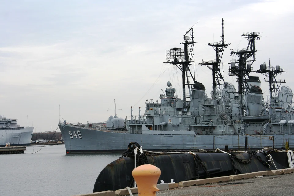 USS Edson docked at the riverfront, with 946 visible on the bow