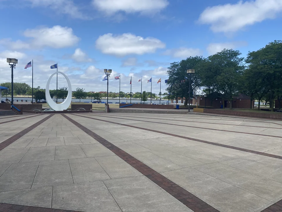 Wenonah Park plaza with flagpoles, trees, and public artwork